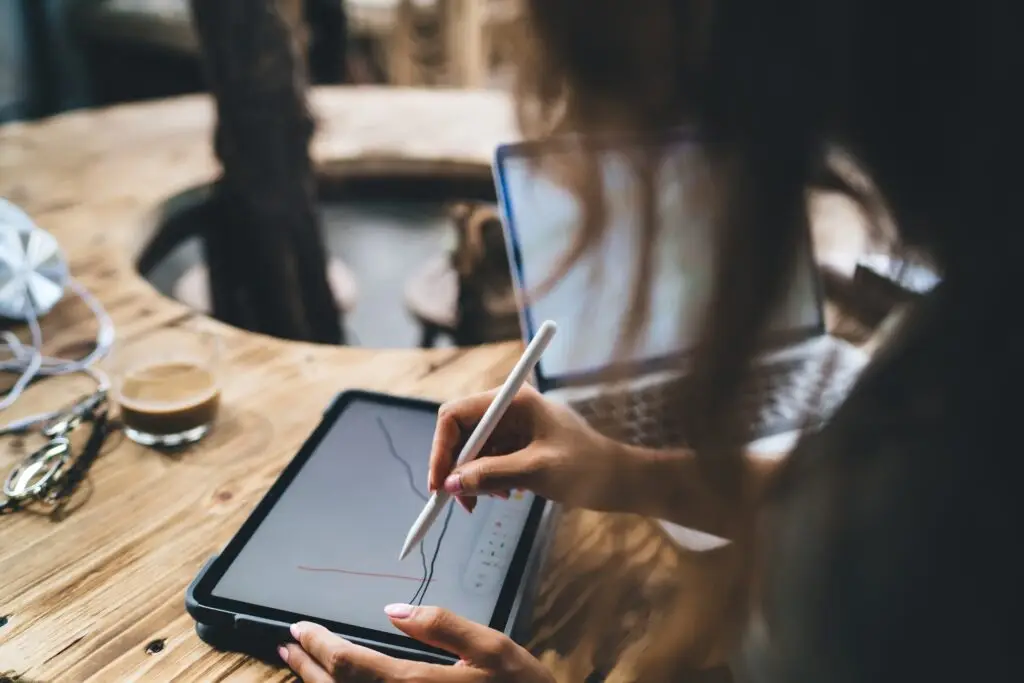 Anonymous woman drawing graph on tablet with stylus